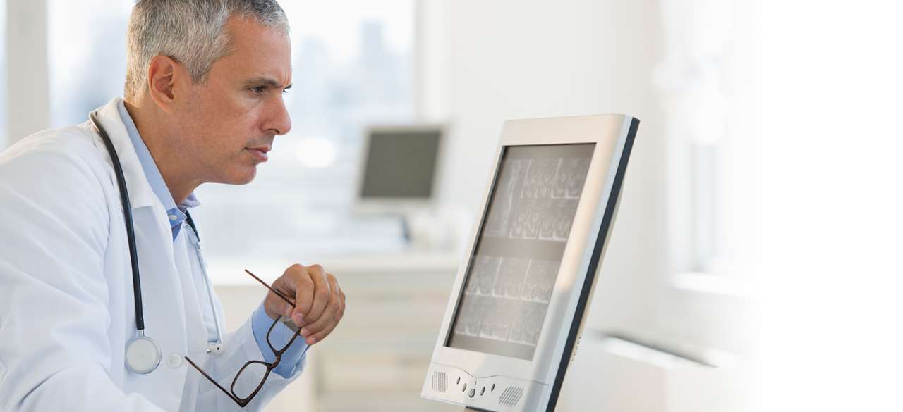 Male doctor looking at medial equipment screen