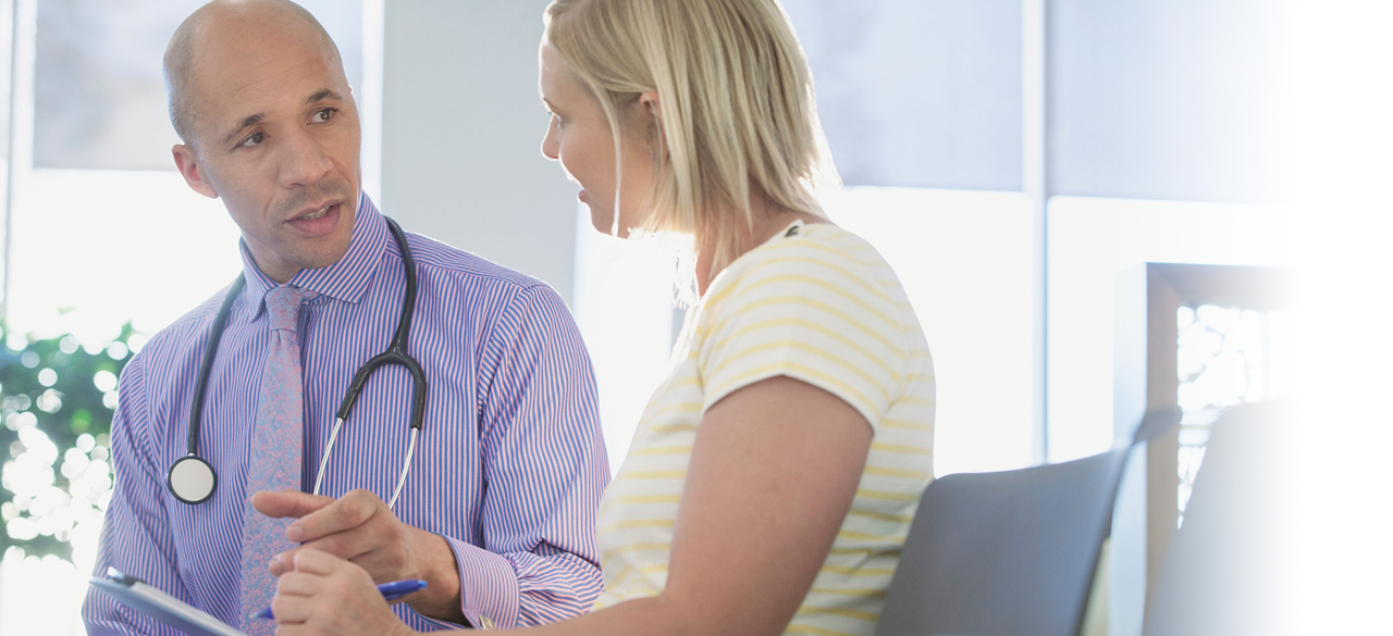 Male doctor speaking to a female patient