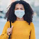 Femme portant un chandail jaune et un masque